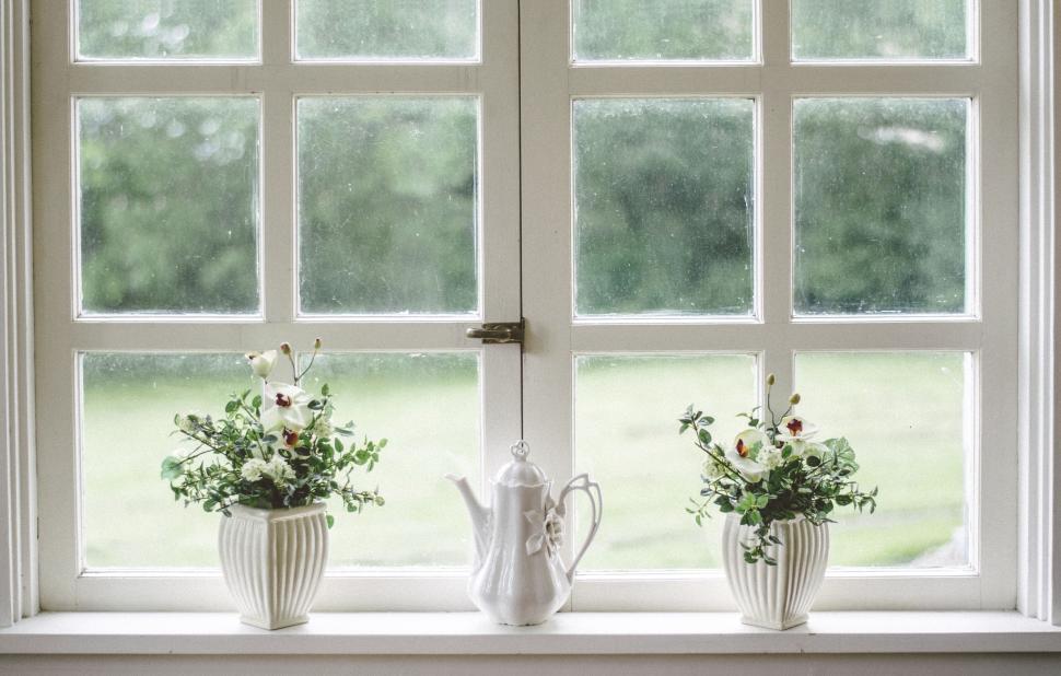 Free Image of Minimalist window view with flowers and decorative teapot 