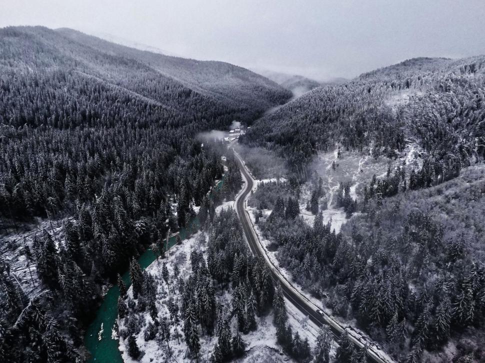 Free Image of Snowy mountain forest with winding road aerial panorama. 