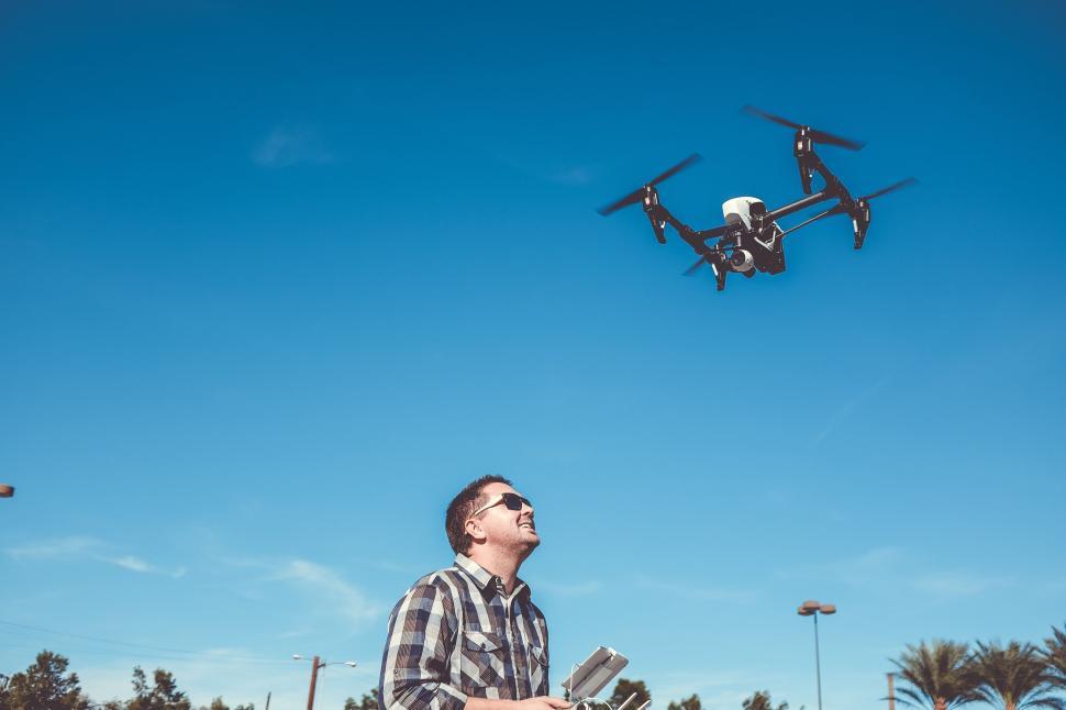 Free Image of Man flying a drone controller in an open space. 