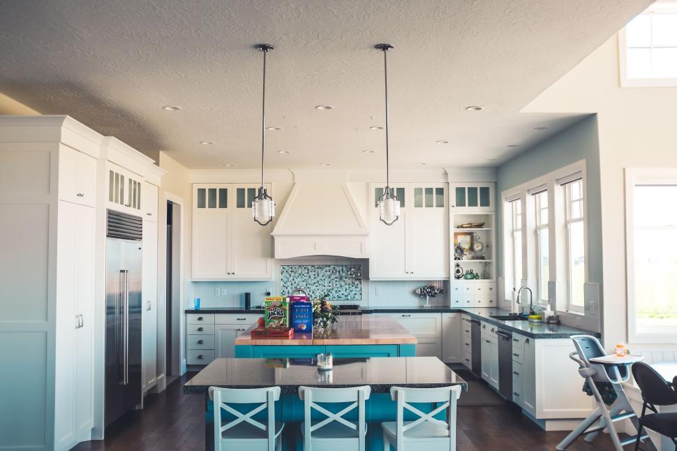 Free Image of Modern kitchen featuring white cabinets and teal island. 