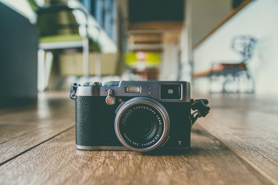Free Image of Vintage camera on wooden floor in a well-lit room. 