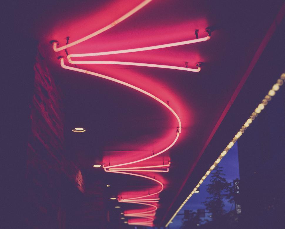 Free Image of Neon lights in a zigzag pattern under a canopy at night 