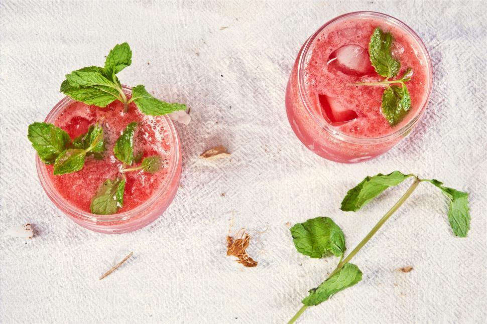 Free Image of Top view of two pink drinks on a table with mint leaves 