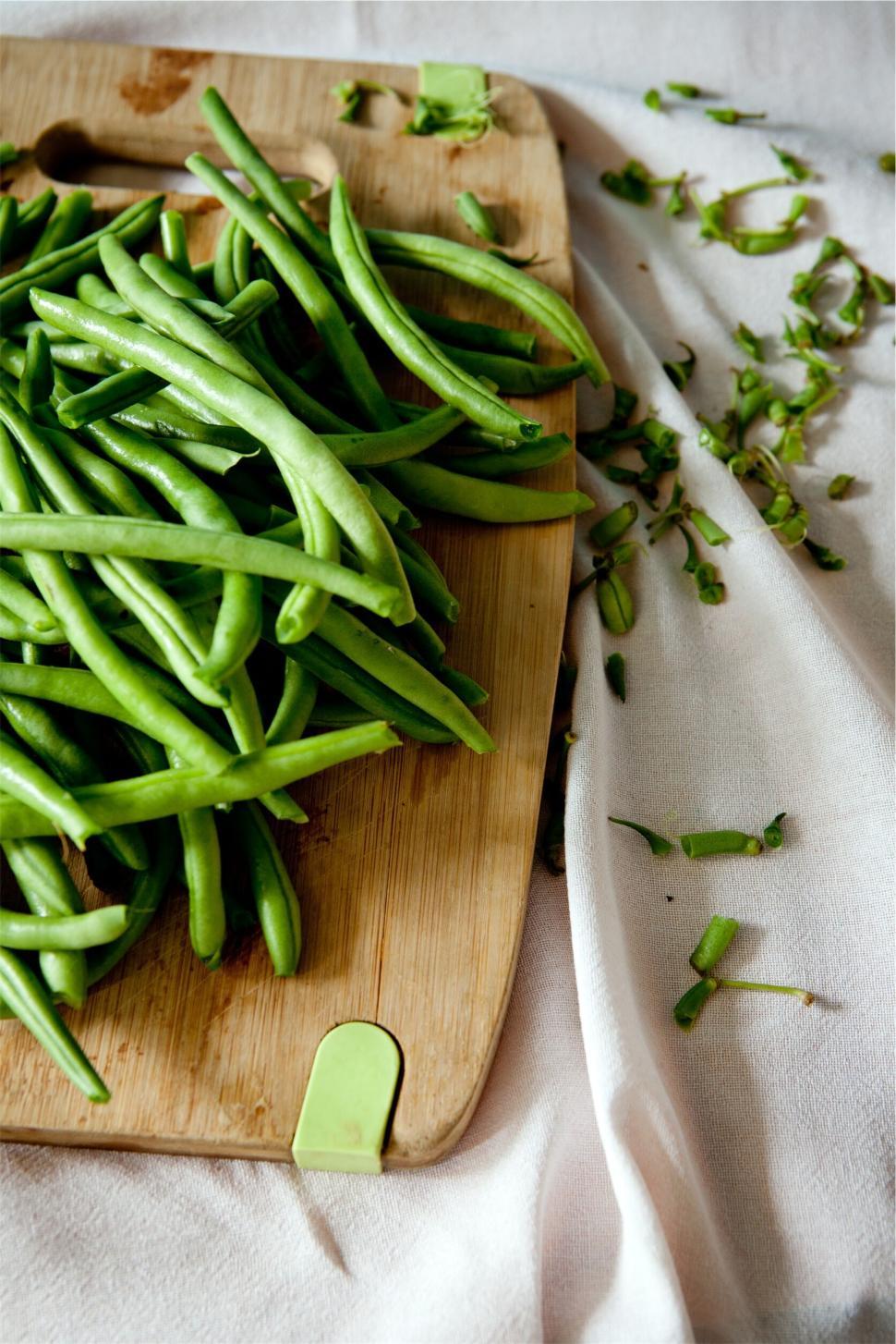 Free Image of Fresh green beans on a wooden board with cut ends 