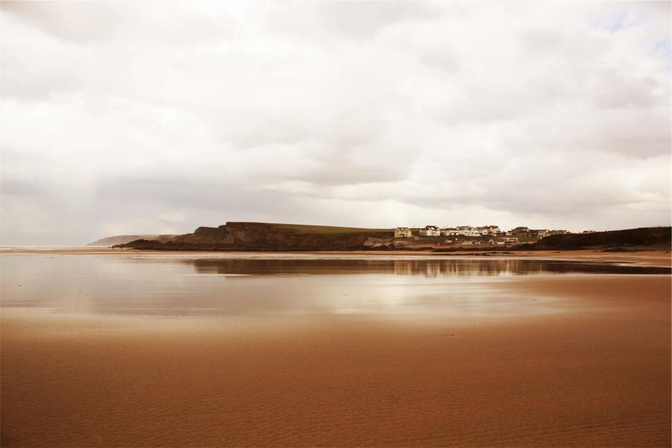 Free Image of Coastal landscape with sandy beach and distant houses 