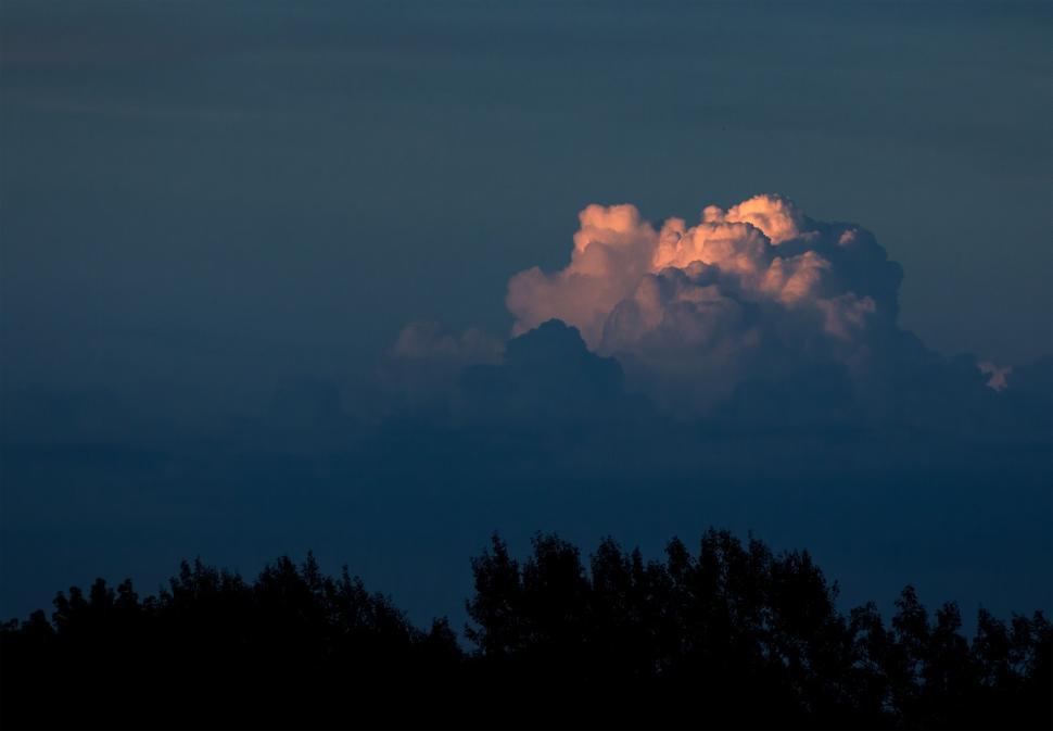 Free Image of Bright cloud illuminated against a darkening sky 
