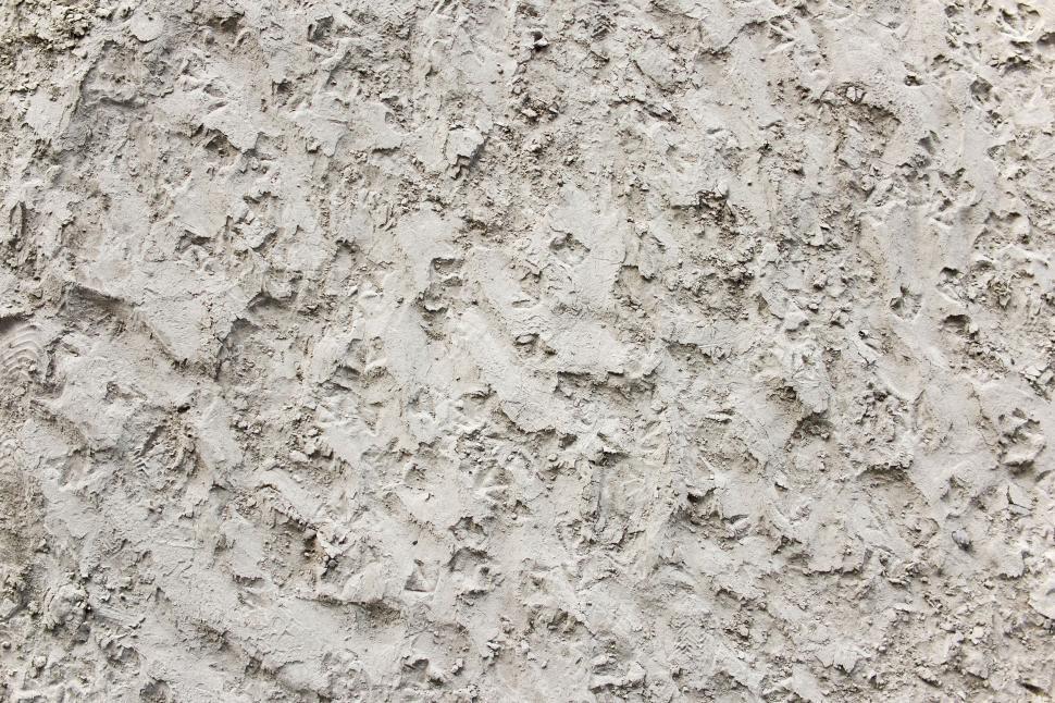 Free Image of Rough, textured wall surface with various marks and dents 