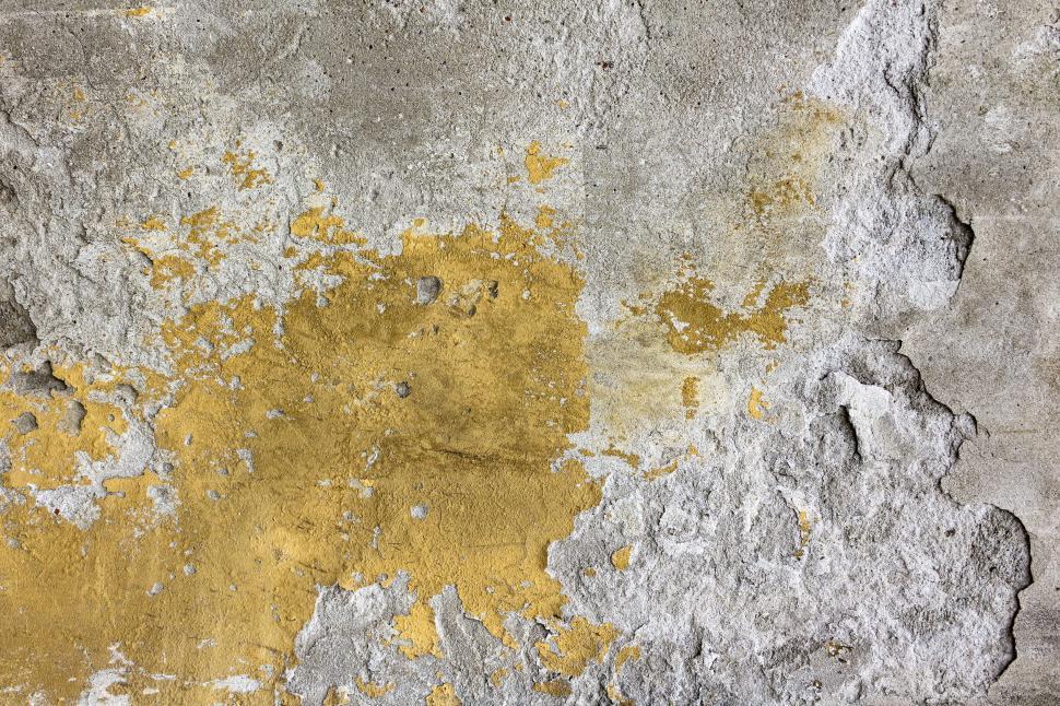 Free Image of Peeling paint revealing a golden underlayer on a wall 