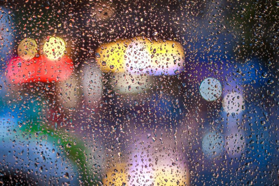 Free Image of Raindrops on windowpane with colorful bokeh lights 