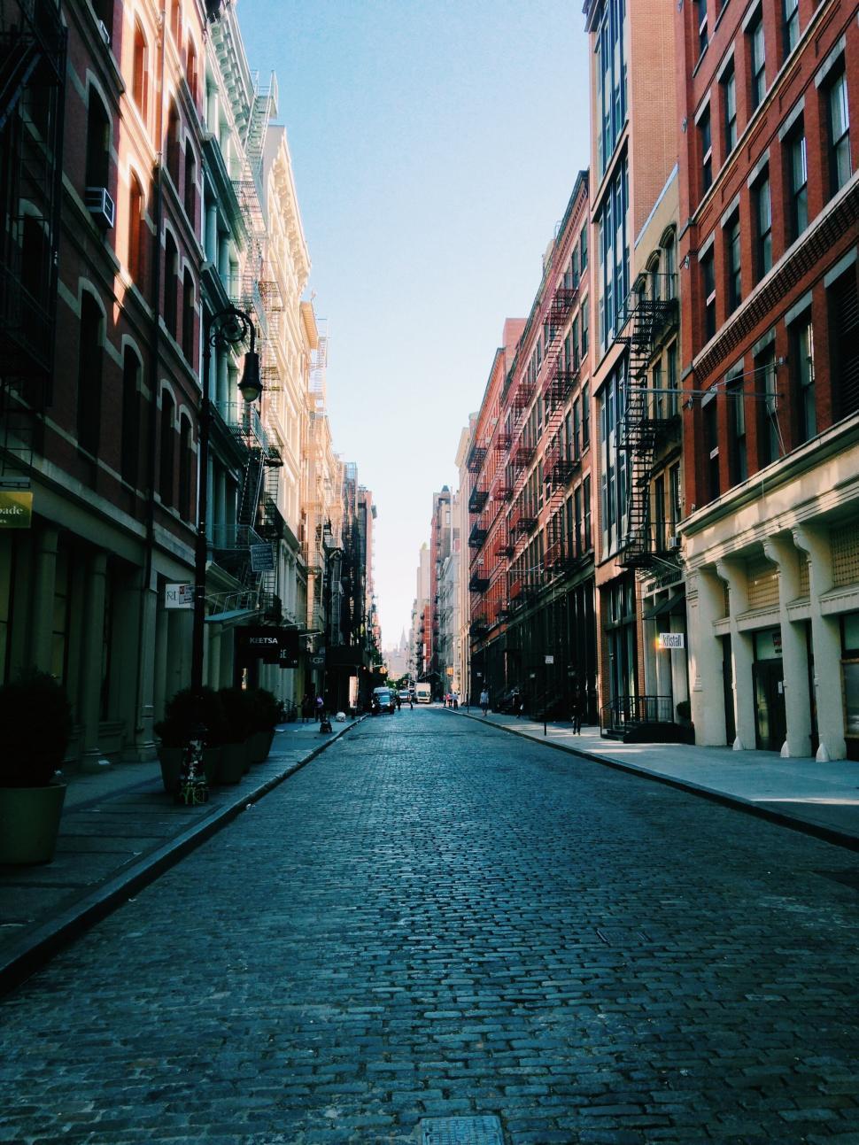 Free Image of Urban street view lined with tall historic buildings 