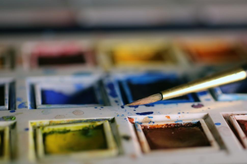 Free Image of Colorful paint palette with brush close-up view. 