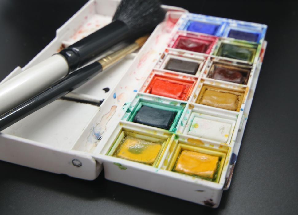 Free Image of Assorted watercolor paints and brushes in a palette. 
