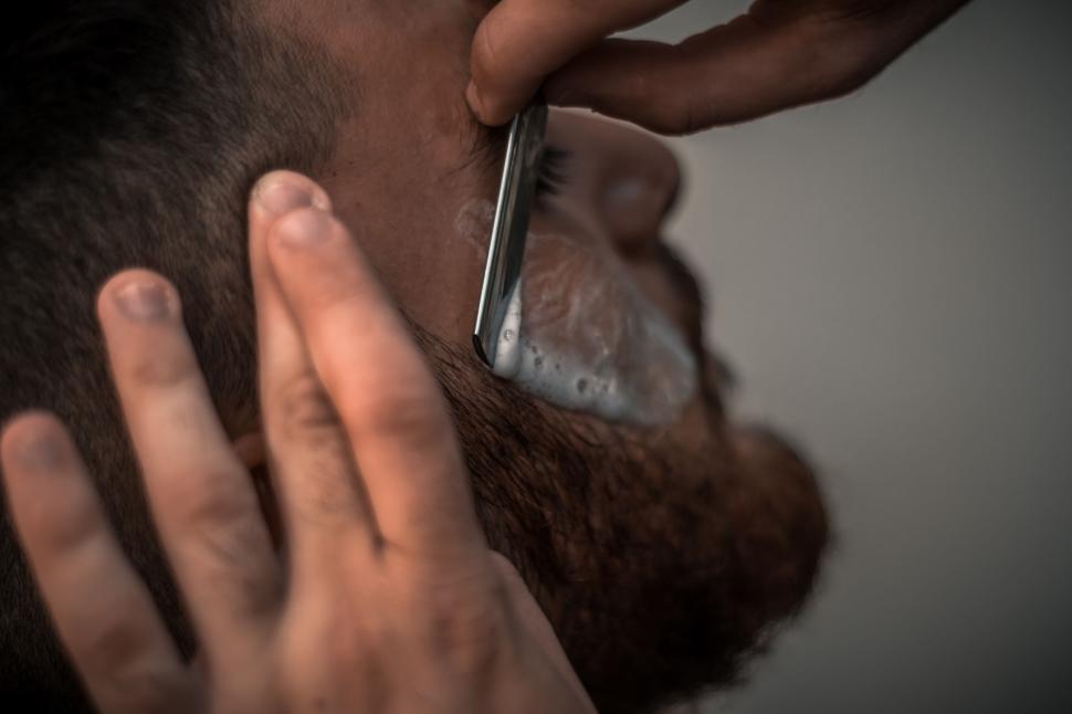 Free Image of Close-up of a man getting a traditional straight razor. 