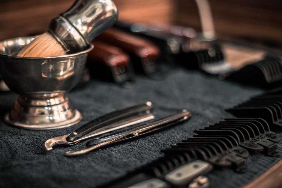 Free Image of Barber tools like razor and brushes on a towel. 
