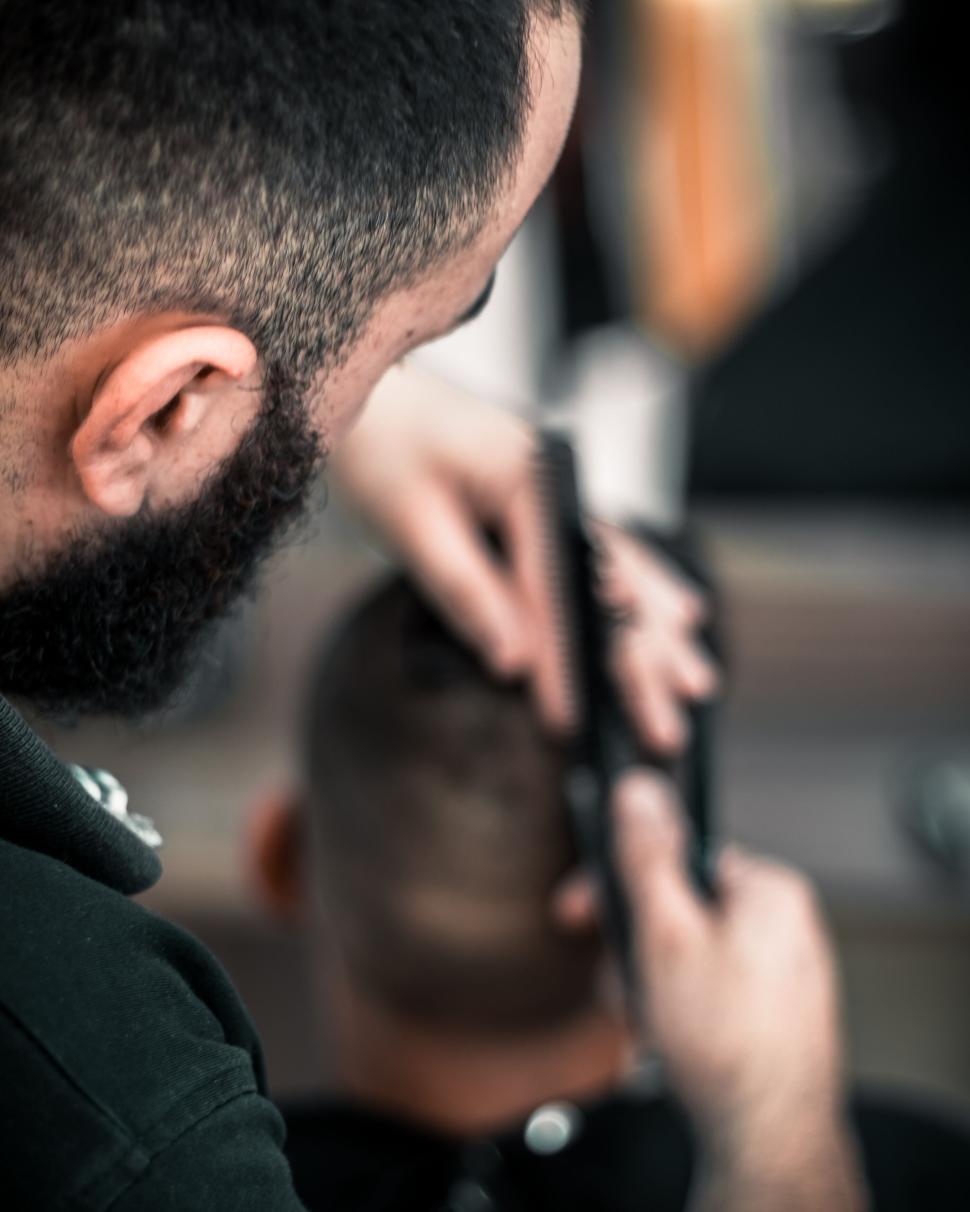 Free Image of Barber giving a haircut in a professional barbershop. 