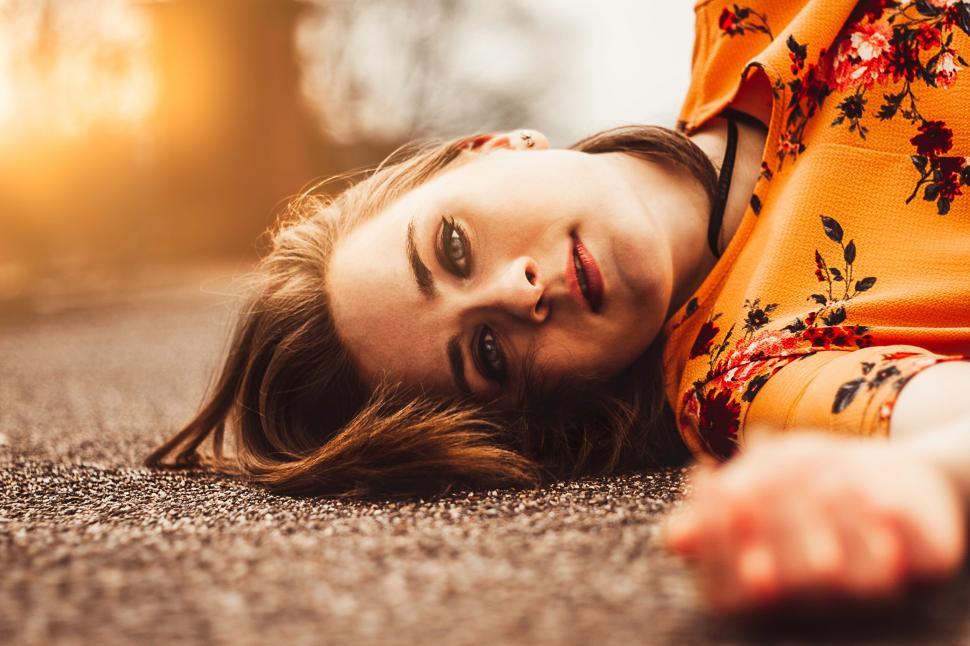 Free Image of Person laying on ground with a floral dress. 