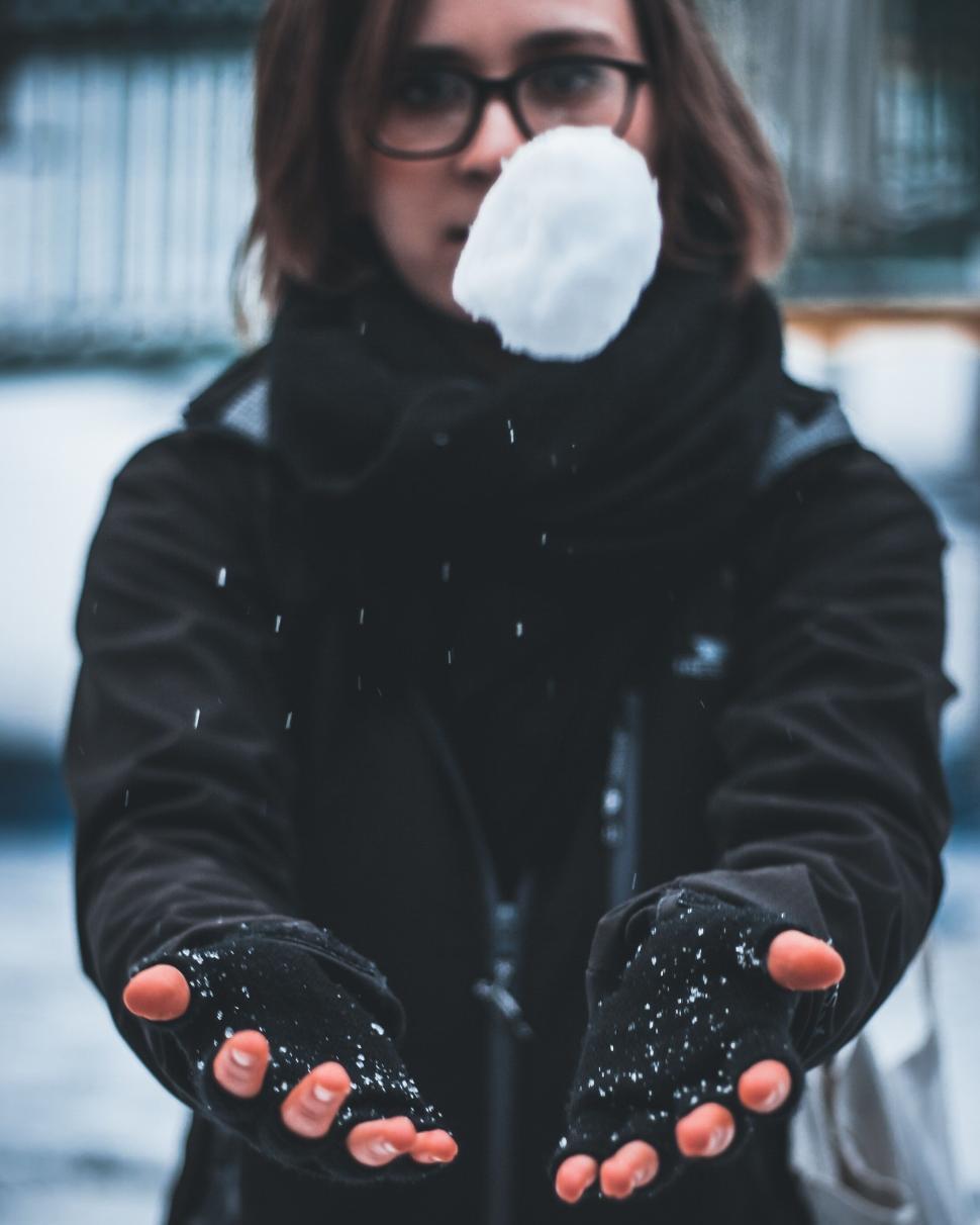 Free Image of Person extending hands to catch falling snowflakes. 
