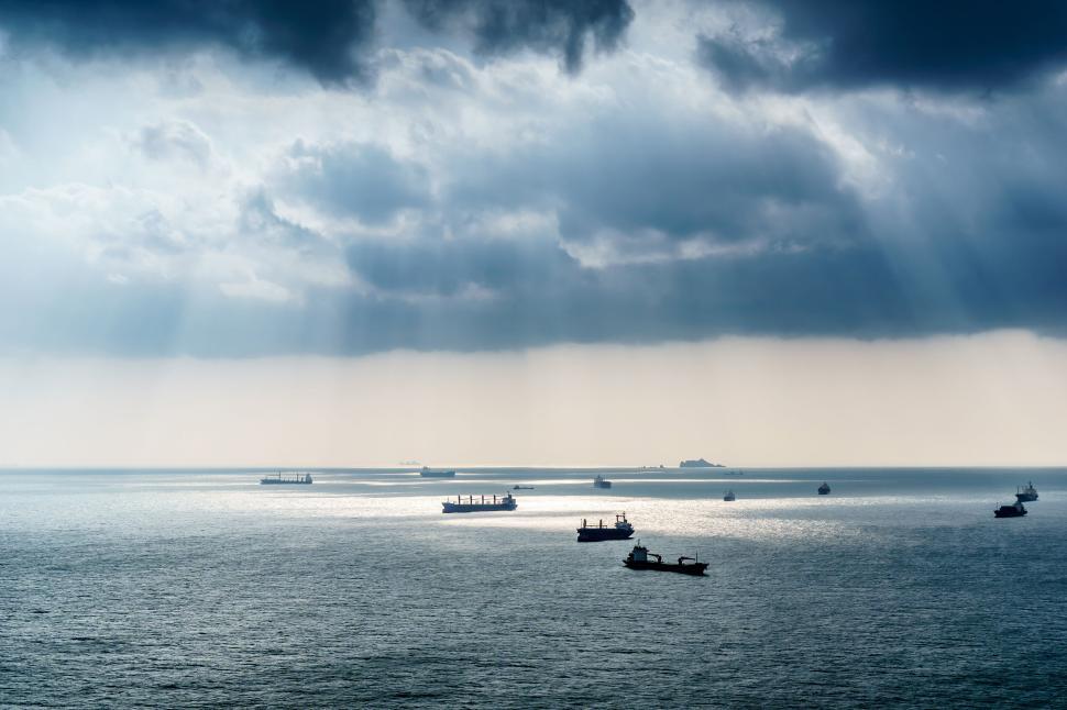 Free Image of Ships and boats anchored on water under cloudy sky 
