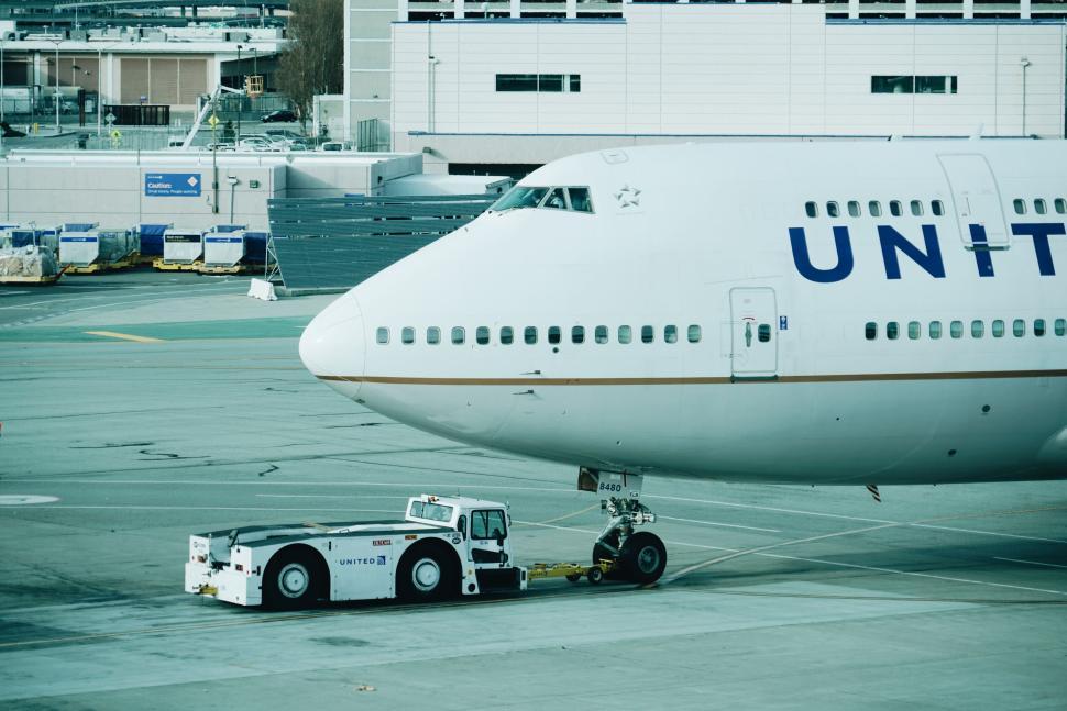 Free Image of Airplane being towed on an airport tarmac. 
