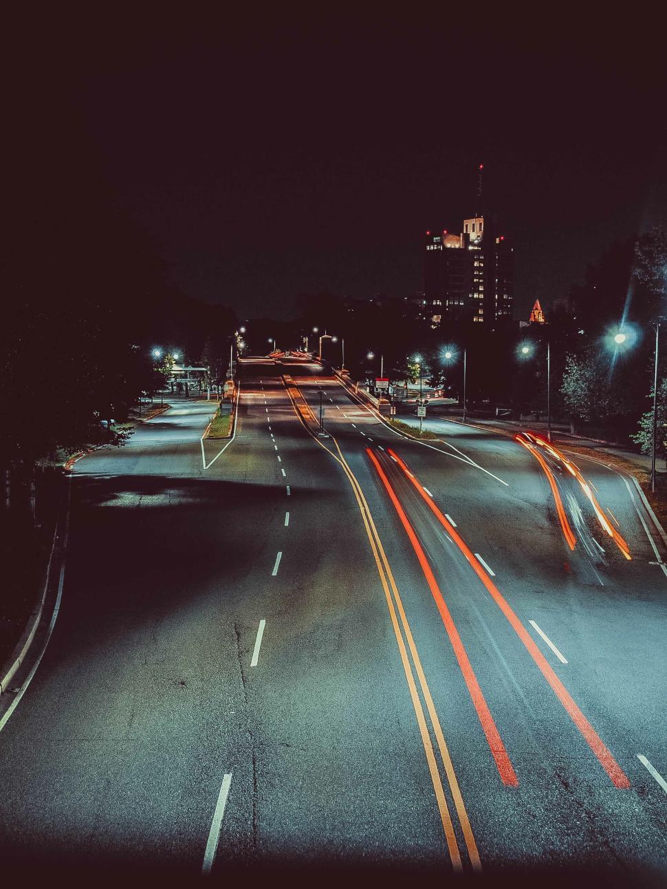 Free Image of Empty city street with light trails at night time view. 