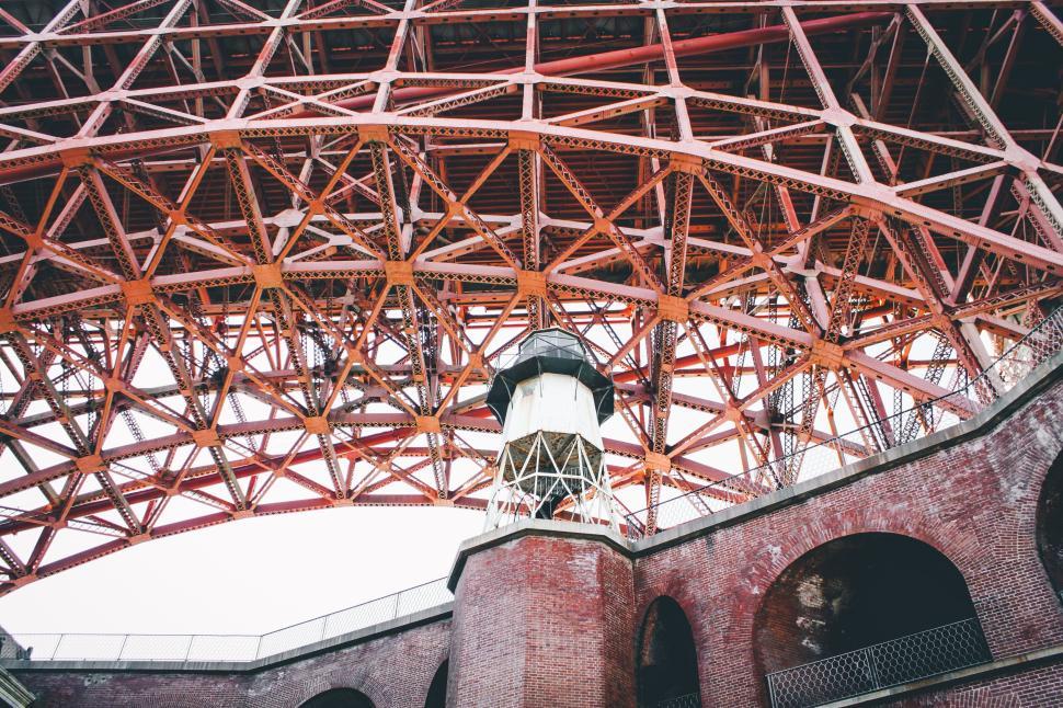 Free Image of Underneath a large famous red bridge showing its structure. 