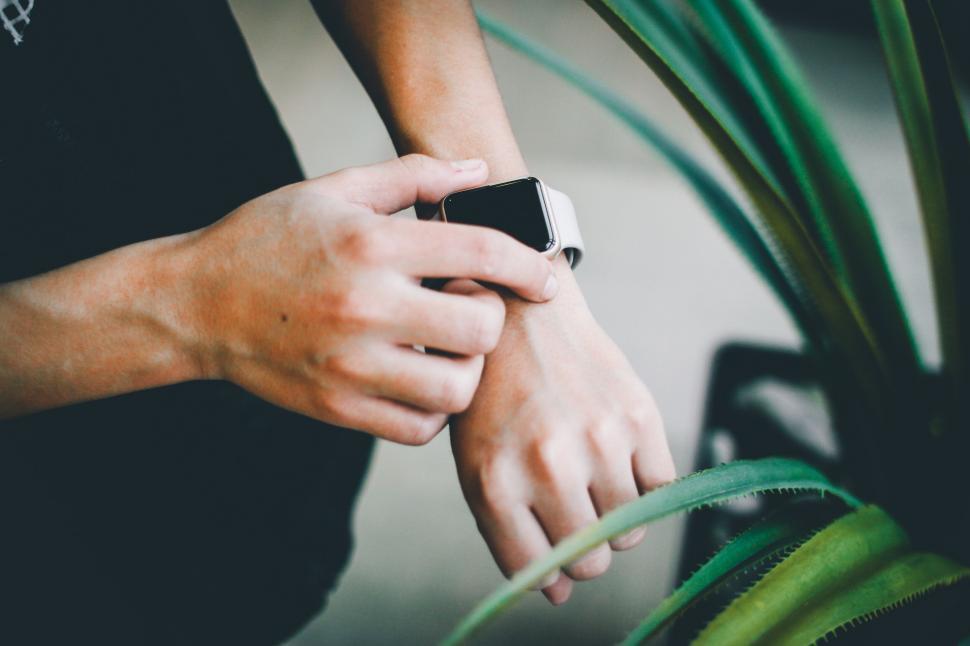 Free Image of Person Checking Smartwatch Near Green Plants Indoors 