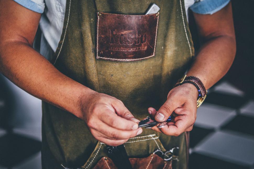 Free Image of Person polishing a tool wearing an apron in workshop 