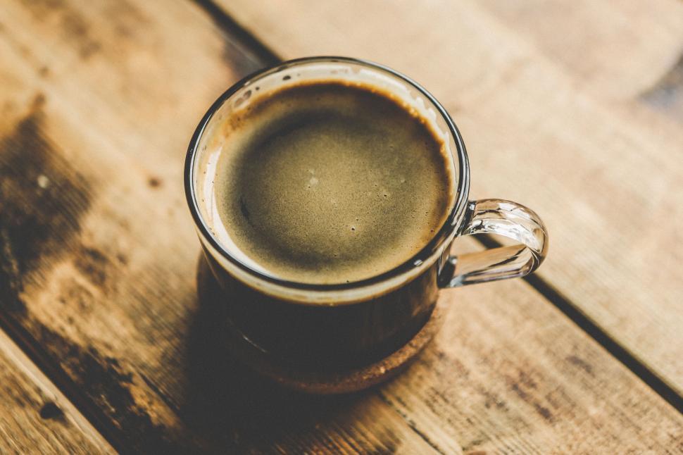 Free Image of Close-up shot of a dark coffee cup on a wooden table. 