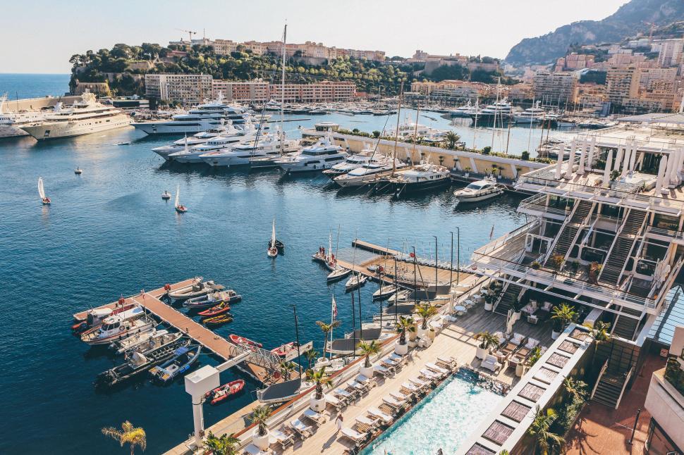Free Image of Luxury yachts docked at a port overlooking cityscape view. 