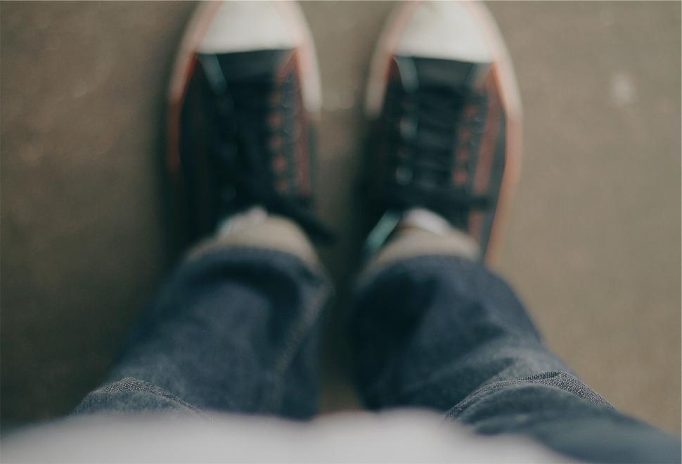 Free Image of Top view of person in sneakers and jeans standing still. 