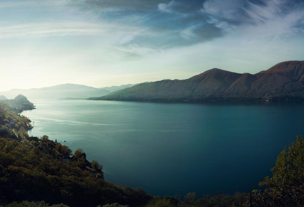 Free Image of Lake surrounded by hills under a clear blue sky. 