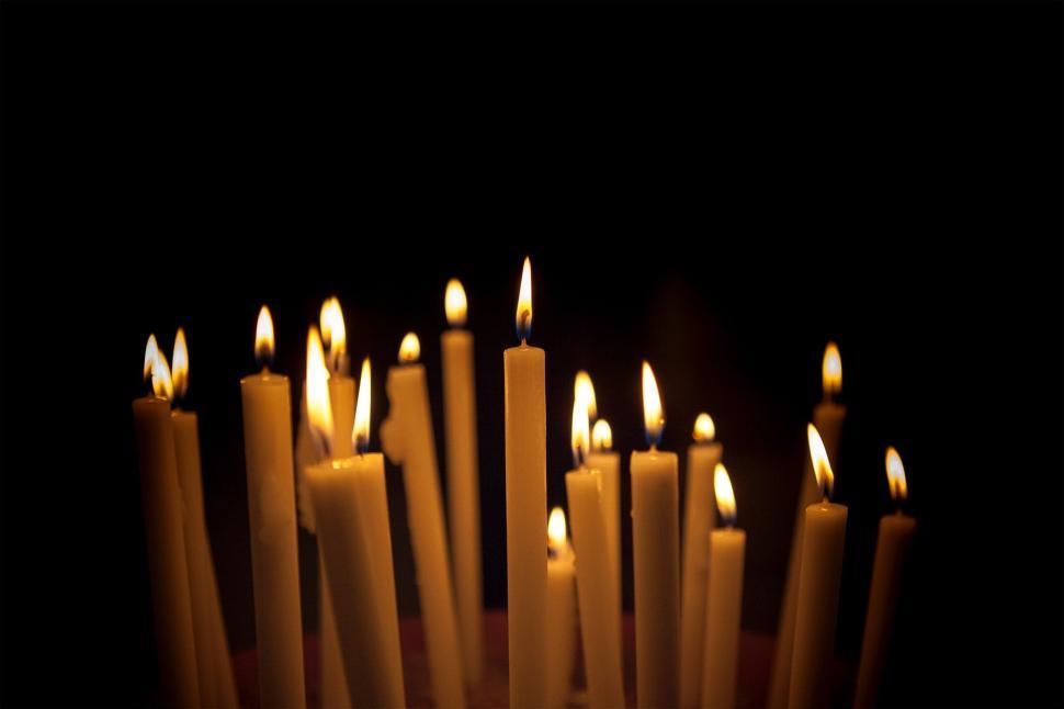 Free Image of Candles burning in the dark creating a warm ambiance. 
