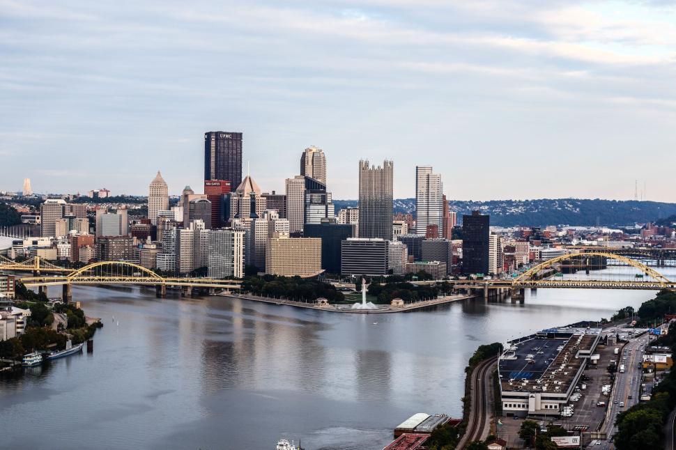 Free Image of City skyline with bridges spanning over a calm river 