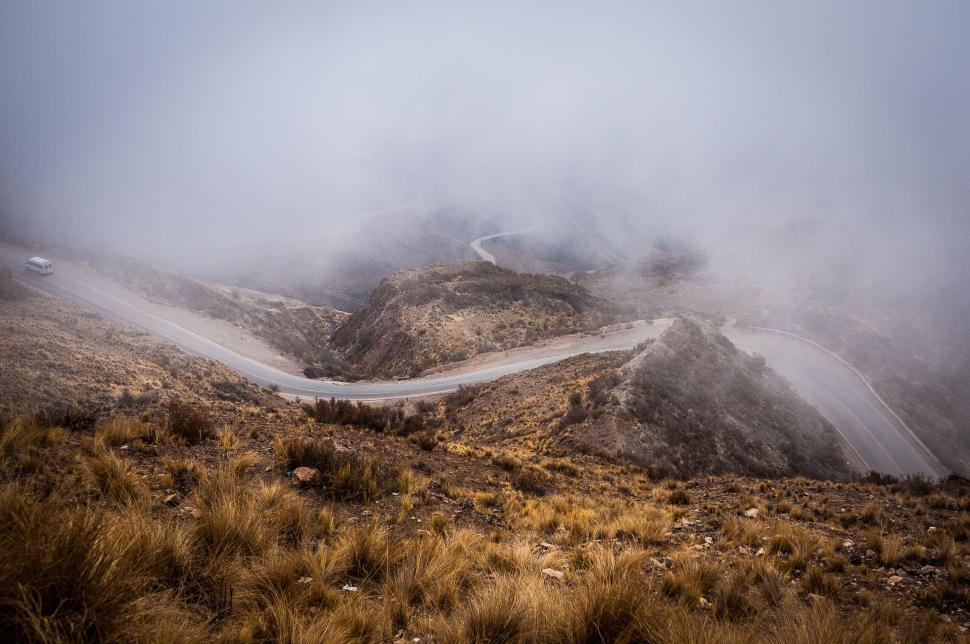 Free Image of A winding road through misty hills in a remote area 