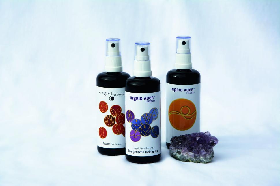 Free Image of Three essential oil bottles with a purple crystal on white. 