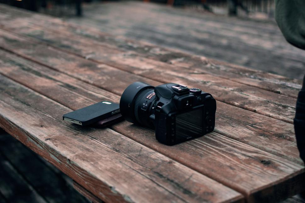 Free Image of Close-up of camera and notebook on rustic wooden table 