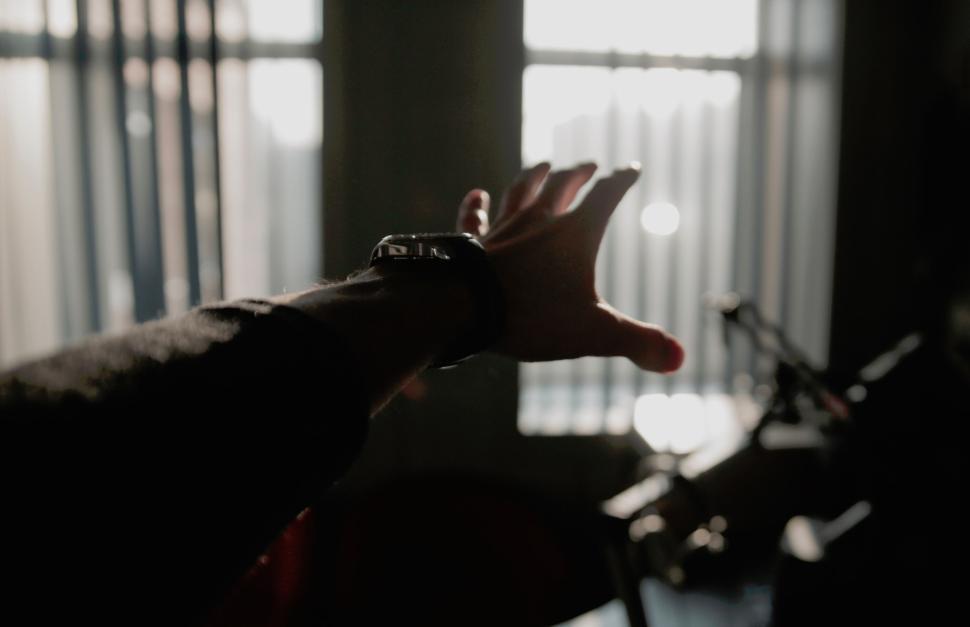 Free Image of Hand reaching towards the sunlight inside a room 
