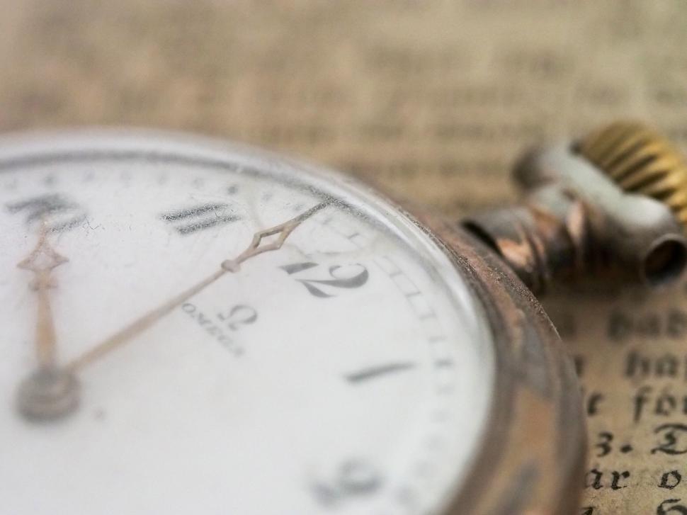 Free Image of Vintage pocket watch and old paper with blurred background. 