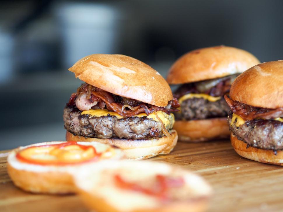 Free Image of Delicious cheeseburgers with bacon served on wooden board. 