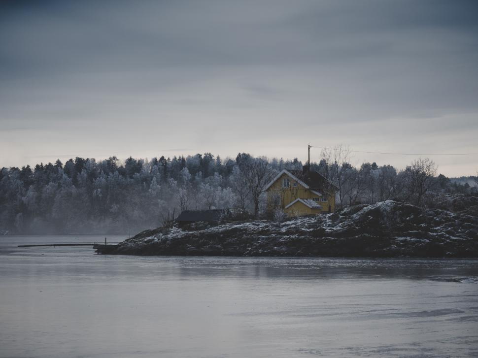 Free Image of Solitary house on a quiet, frozen lakeside landscape. 