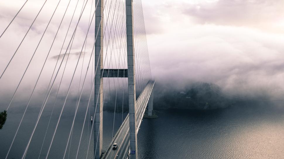 Free Image of Suspension bridge with fog and water below, stunning view 