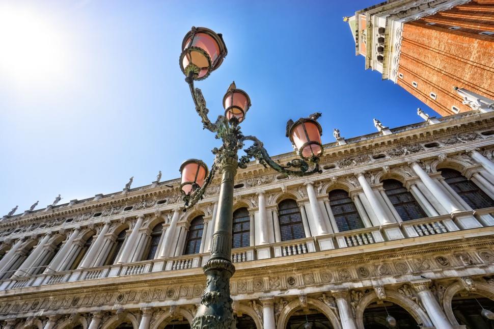 Free Image of Ornate historic building with streetlights, bright blue sky 