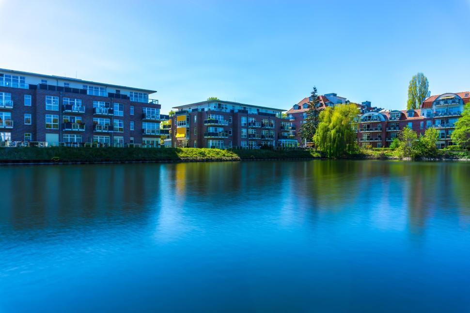 Free Image of Modern apartment buildings by a calm, reflective river 