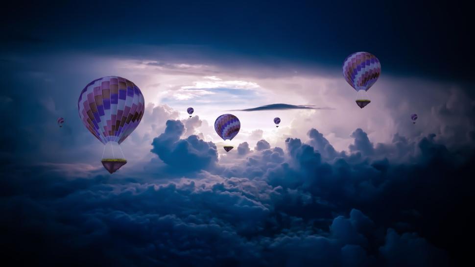 Free Image of Hot air balloons soaring through a dramatic cloudy sky 