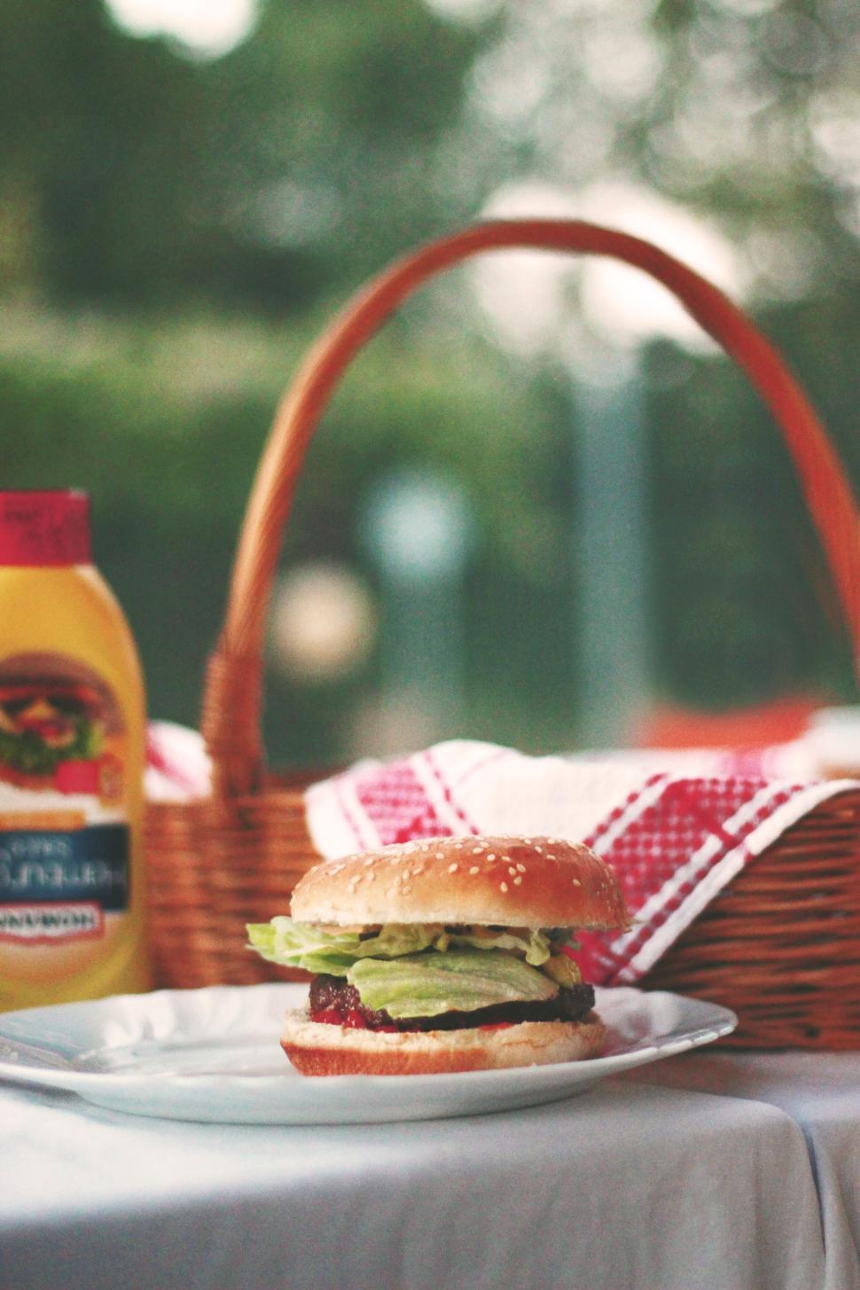 Free Image of Burger with basket in background sitting on a plate. 