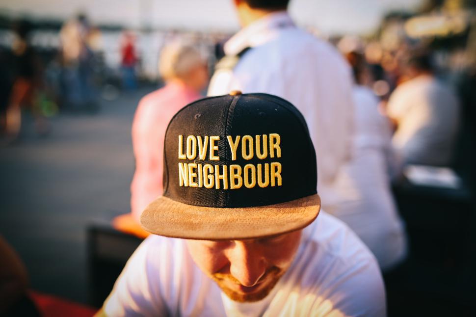 Free Image of Hat with message  Love Your Neighbour  worn at a event. 
