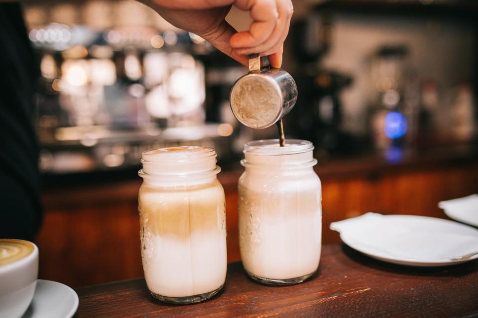 Free Image of Pouring coffee into mason jars in a cozy coffee shop 