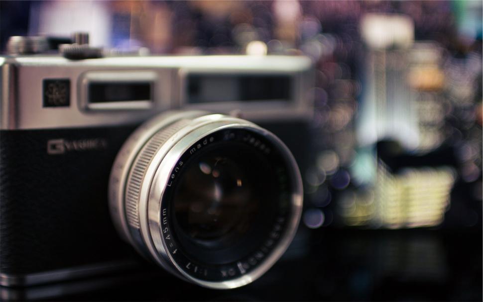 Free Image of Vintage camera on a reflective surface, blurred background 