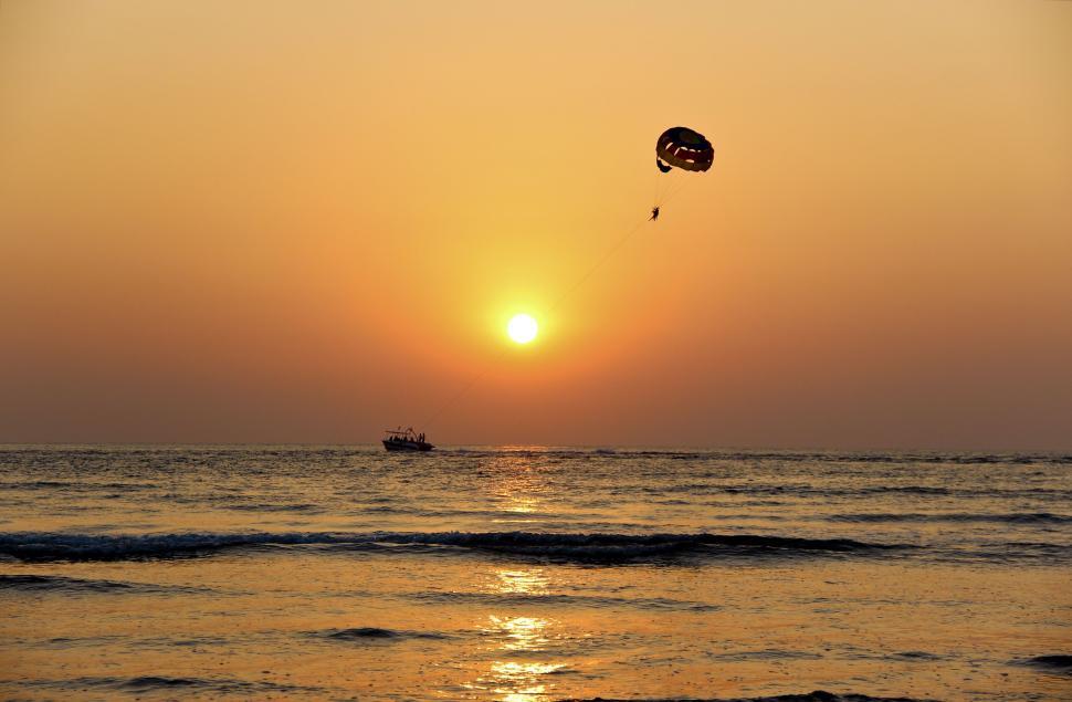 Free Image of Parasailing adventure at sunset with orange-hue sky 