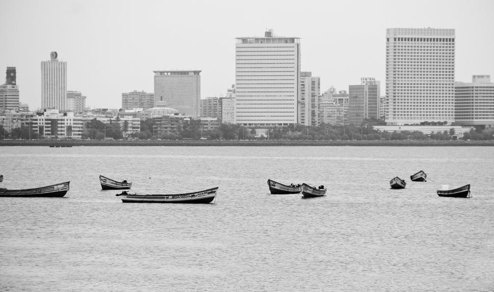 Free Image of Black-and-white cityscape with boats on the water. 